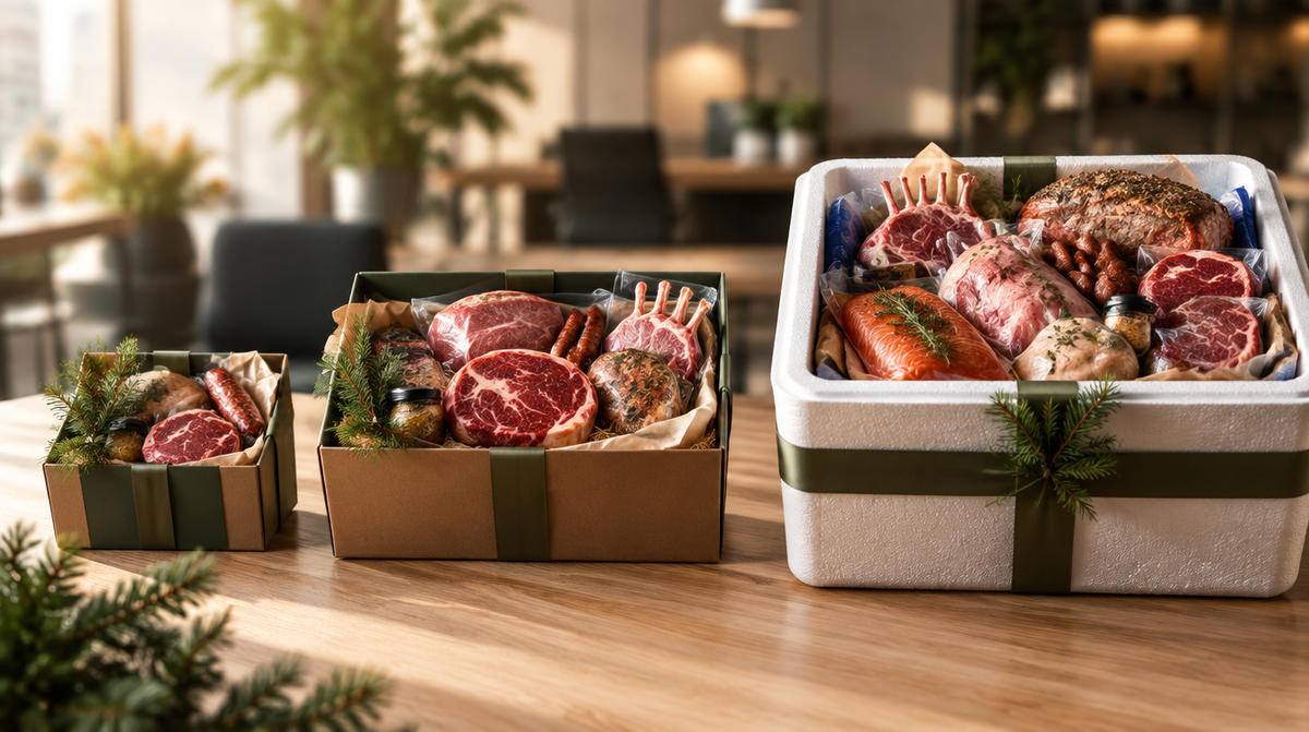 Drie kerstpakketten met vlees in oplopende grootte op een houten tafel