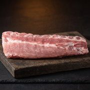 Dik bevleesde spareribs op een houten plank